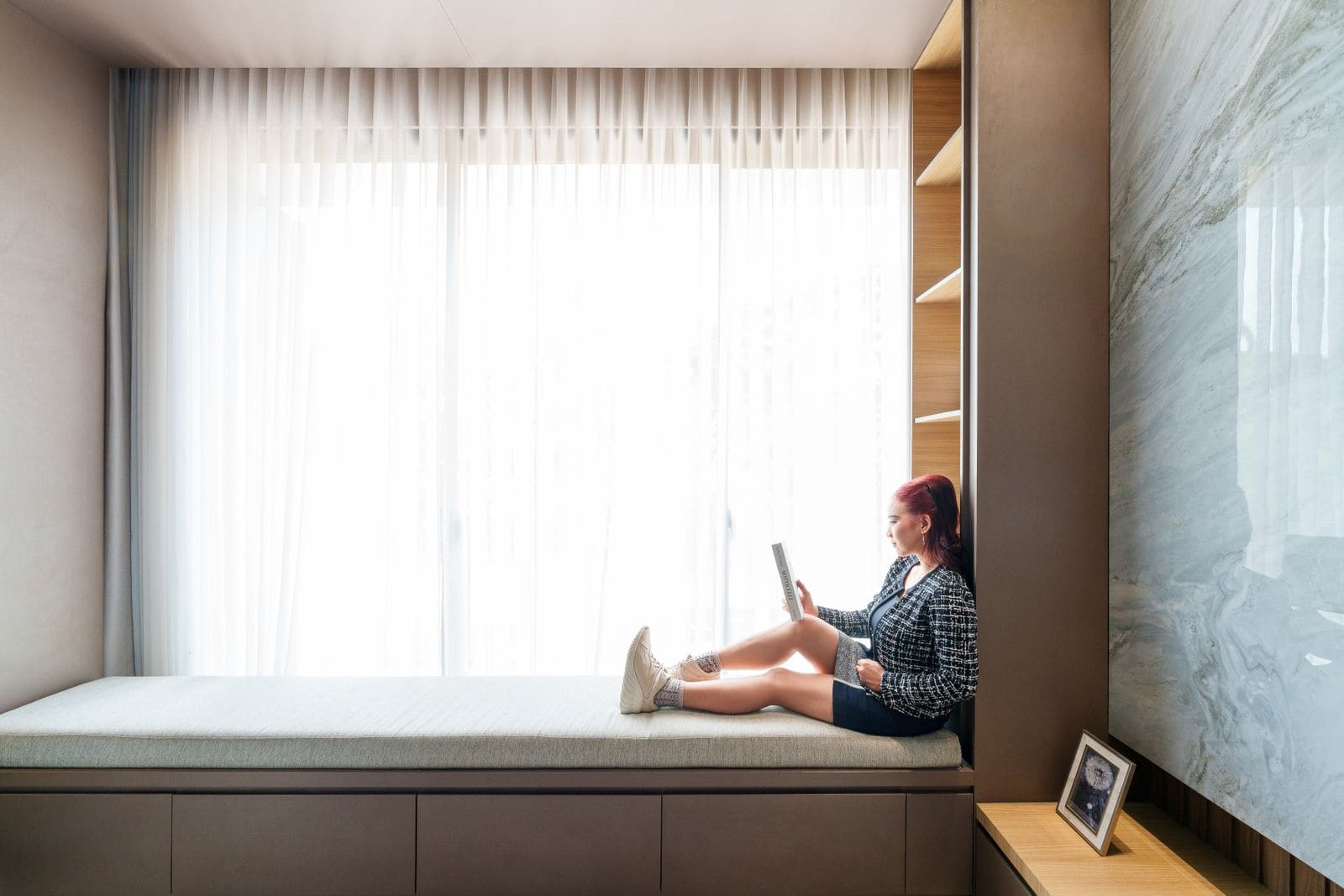 Woman reading on a tablet by a sunny window