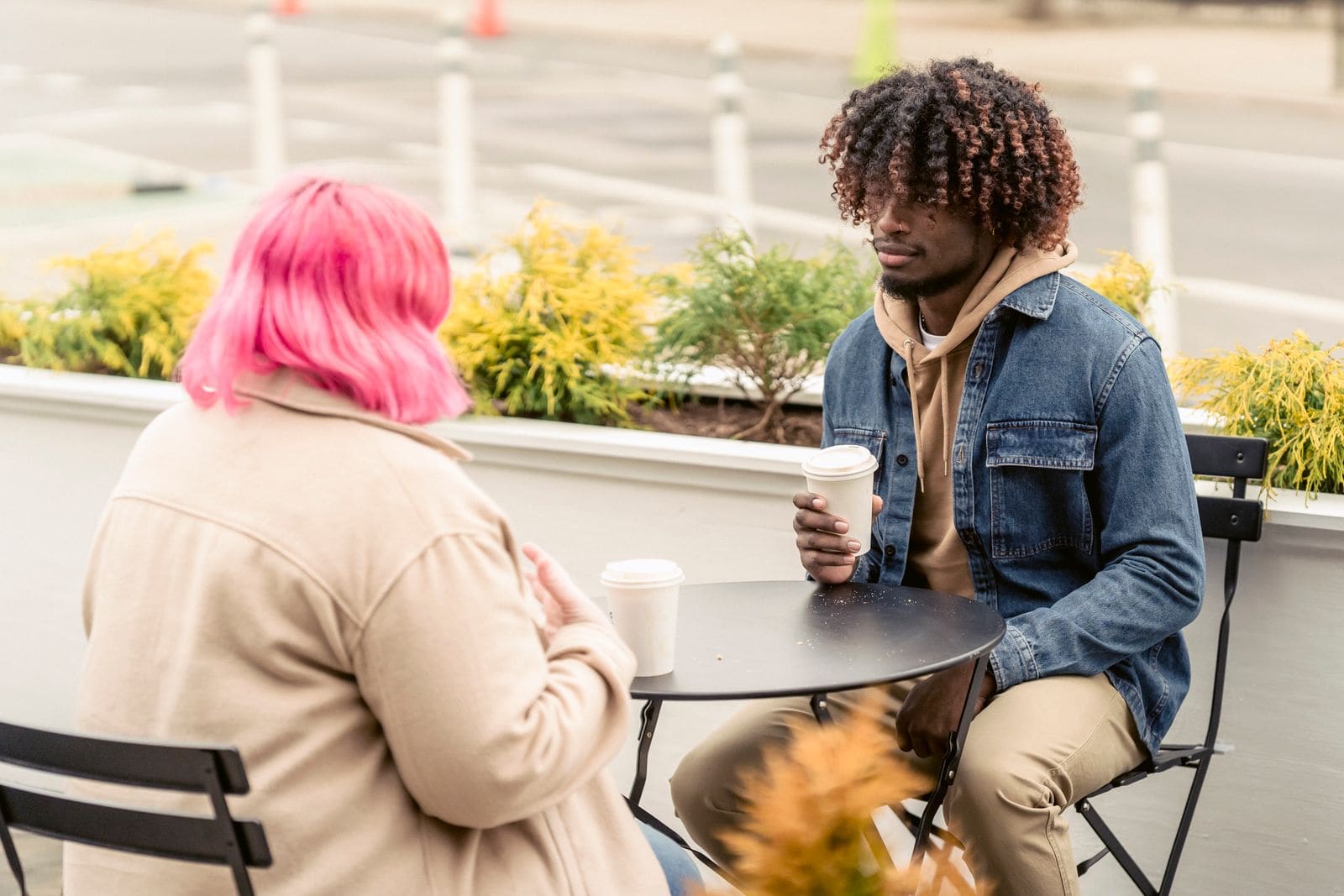 Two friends talking over coffee outdoors