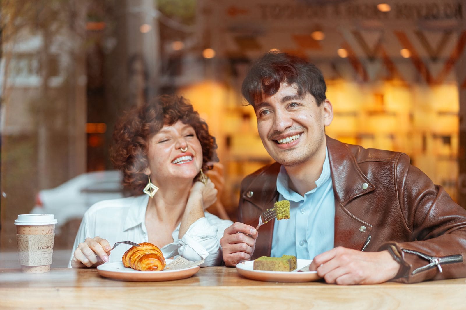 Two people laughing together at a café