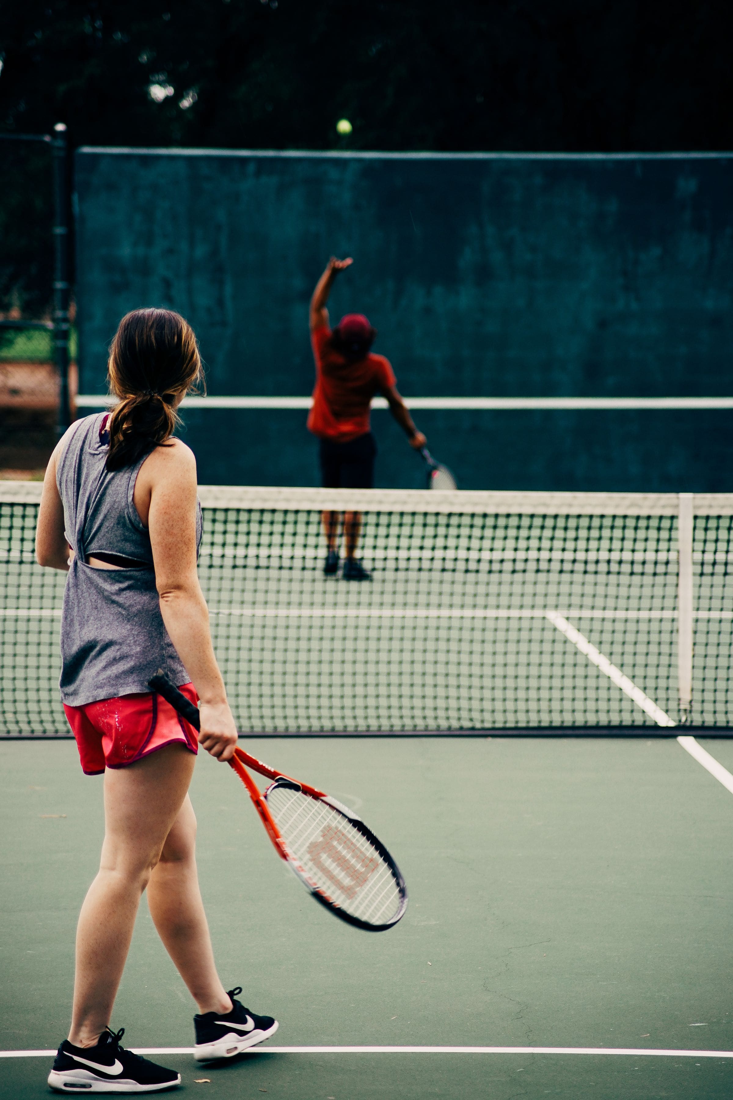 Two adults playing tennis together on an outdoor court