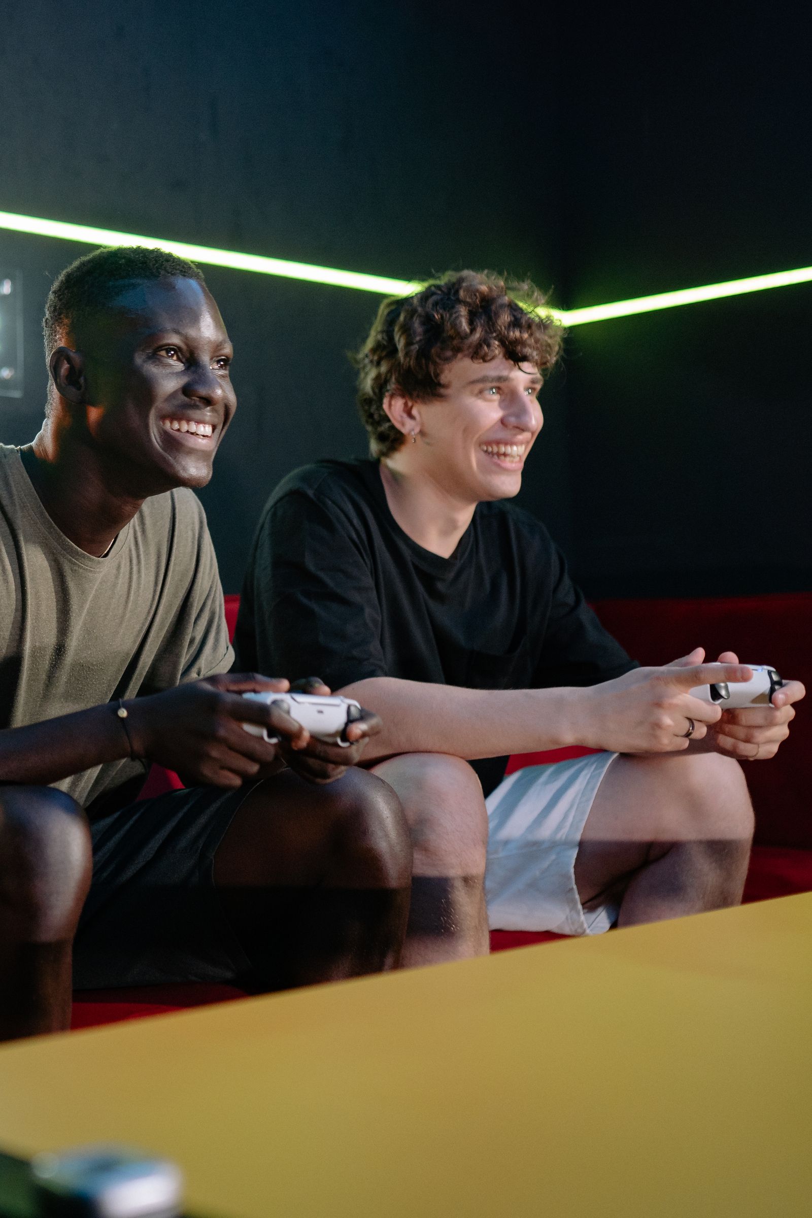 Two friends smiling while playing video games with controllers