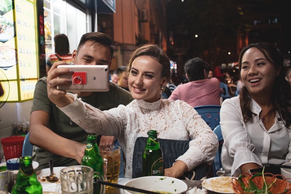 Friends taking a photograph together over dinner