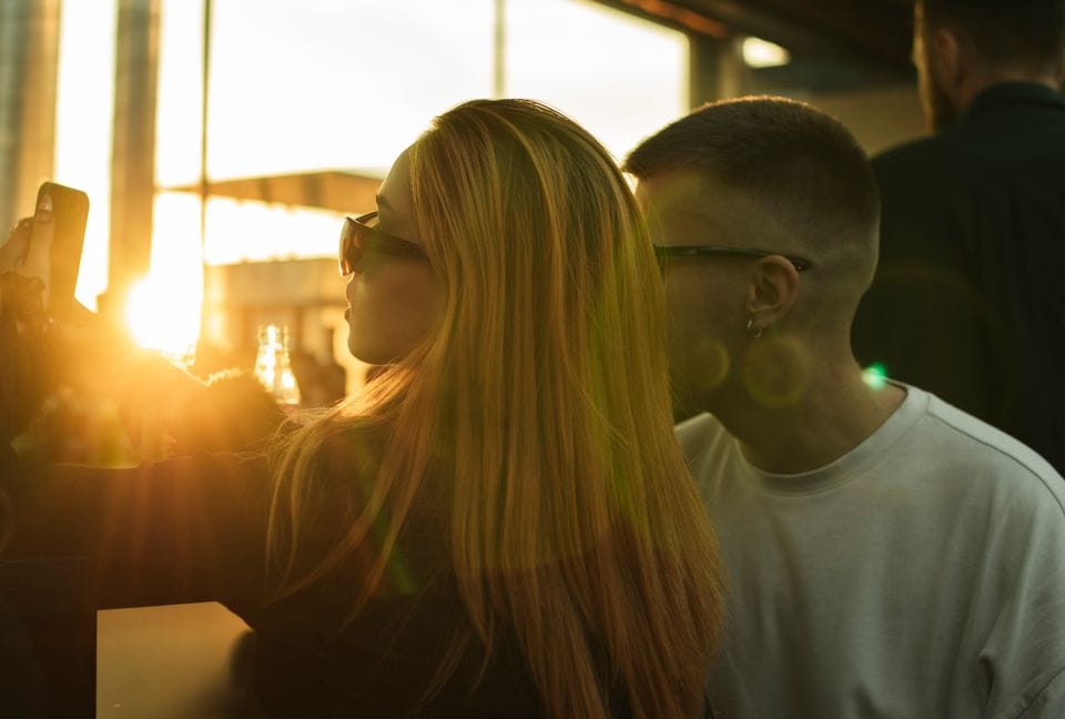 Two people taking a photo together at sunset