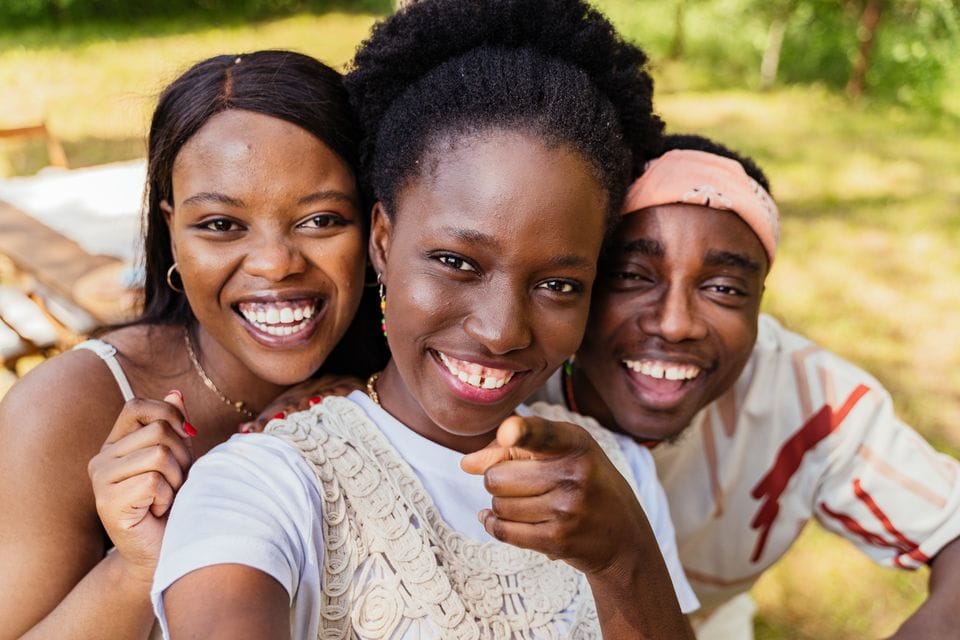 Three friends smiling together outdoors