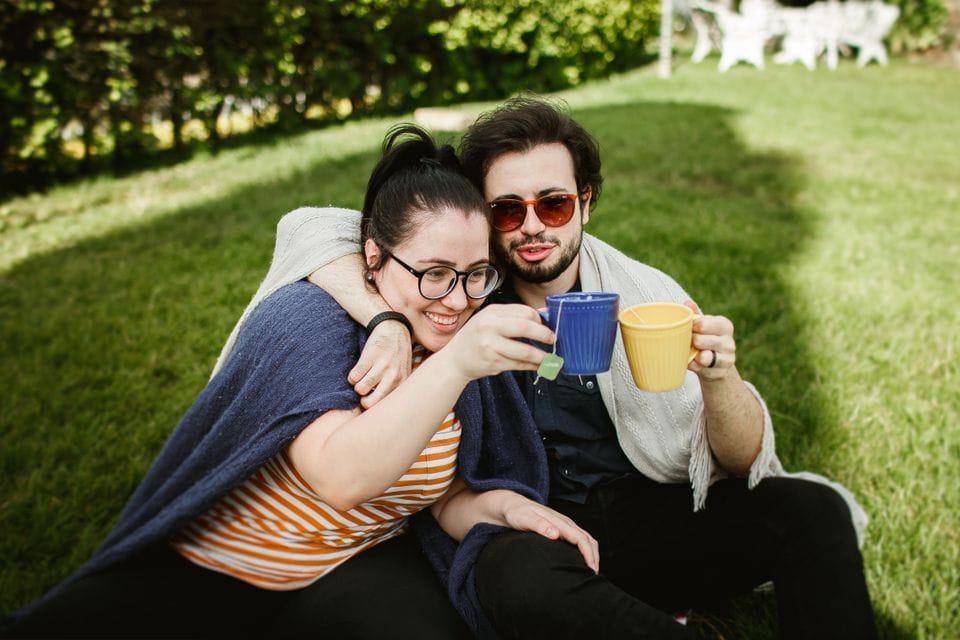Two people sharing a drink in a park